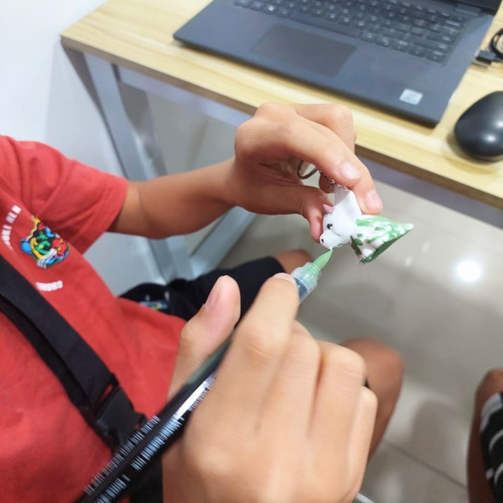 A child painting the piece they designed and 3D-printed at Kunoa